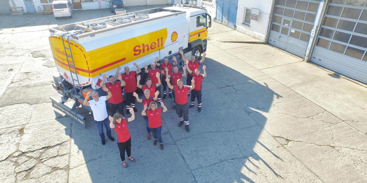 Menschengruppe steht vor Shell-TKW.
