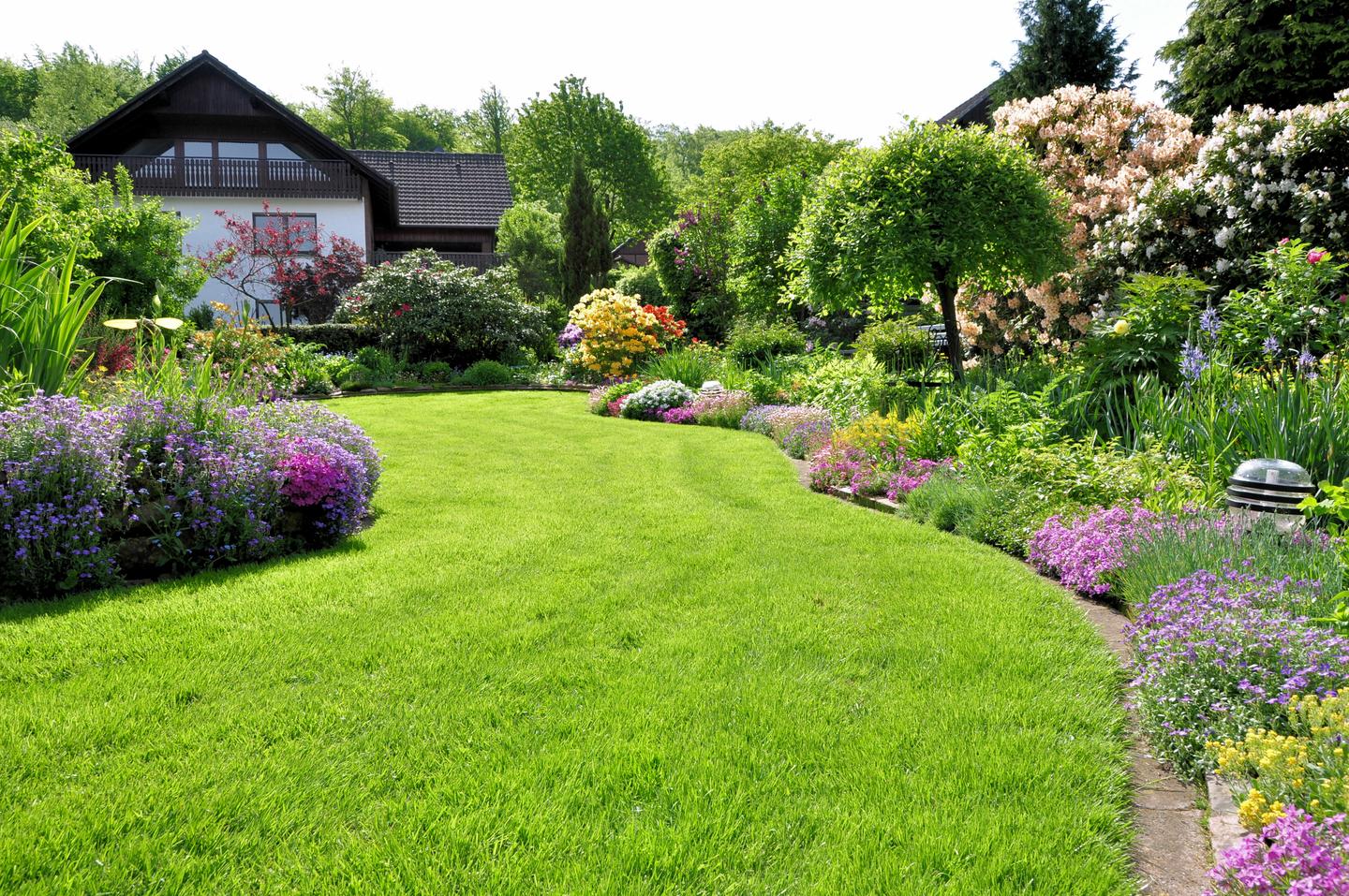 großer Garten mit gepflegtem Rasen und angelegten Beeten