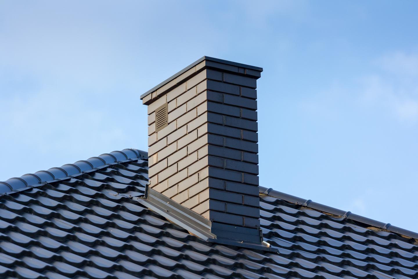dunkles Dach mit Schornstein aus Mauerwerk
