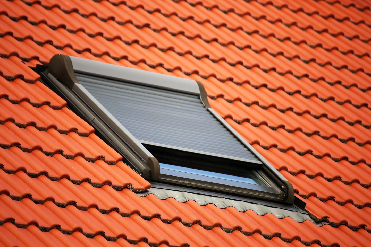 rotes Dach mit Dachfenster und Sonnenschutz